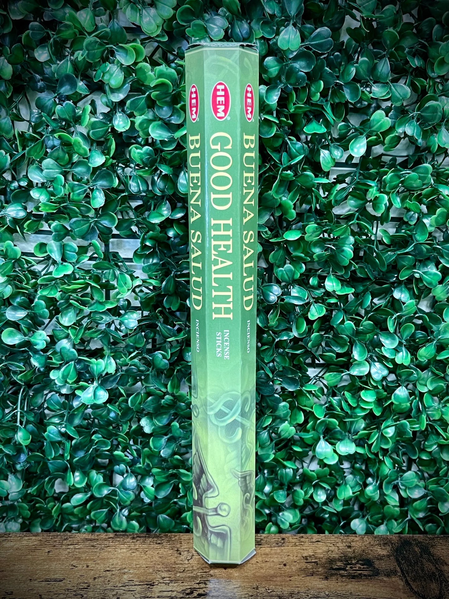 Green box of HEM Buena Salud Good Health incense sticks against a green leafy background