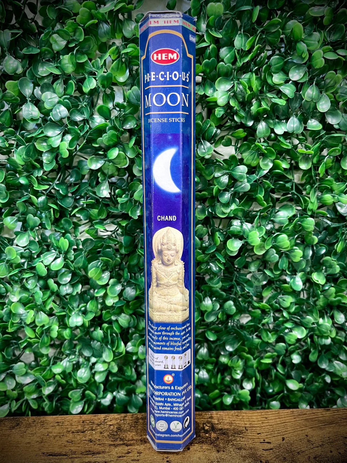 Hem incense stick packaging with a blue label against a green leafy background