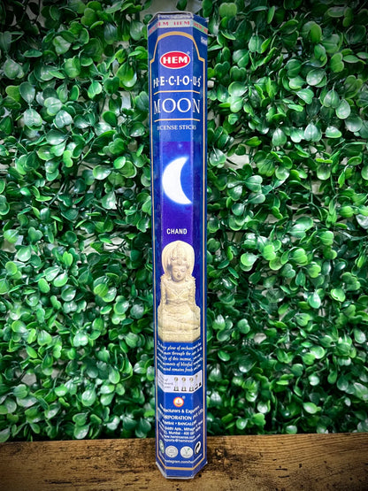 Hem incense stick packaging with a blue label against a green leafy background