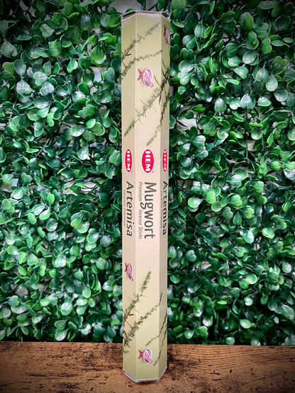 Box of Artemisa Mugwort incense sticks against a green leafy background