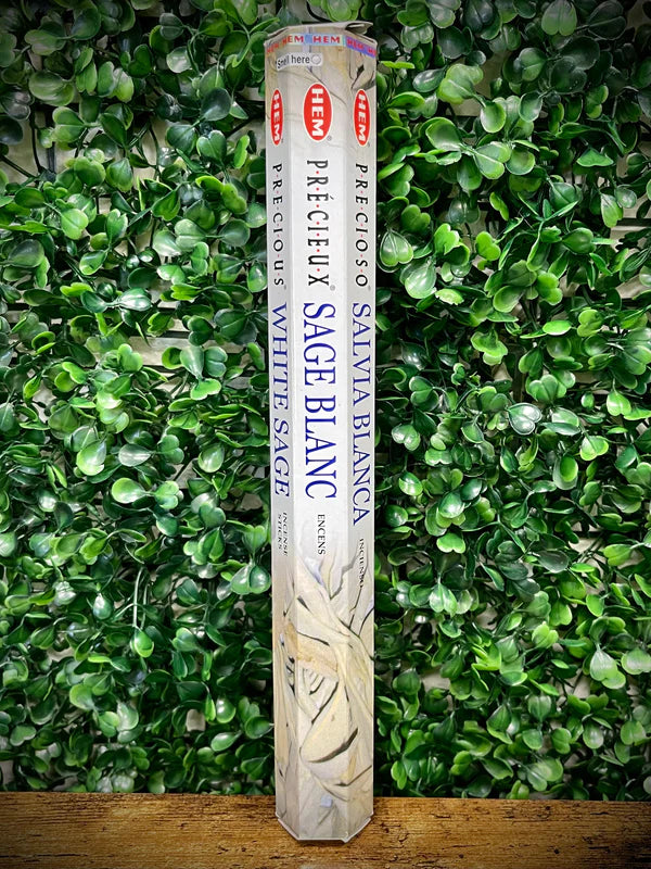 Pack of white sage incense sticks against a green leafy background