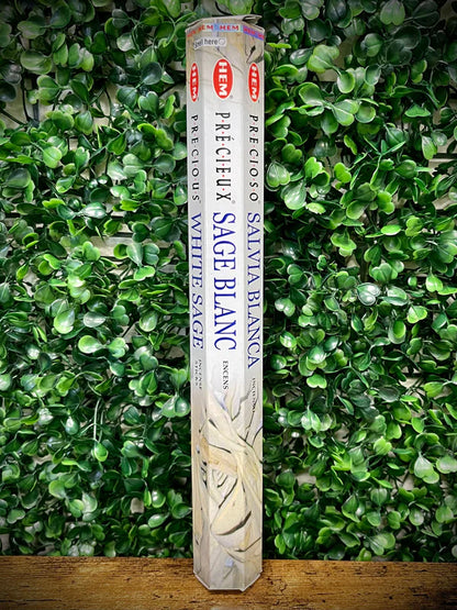 Pack of white sage incense sticks against a green leafy background
