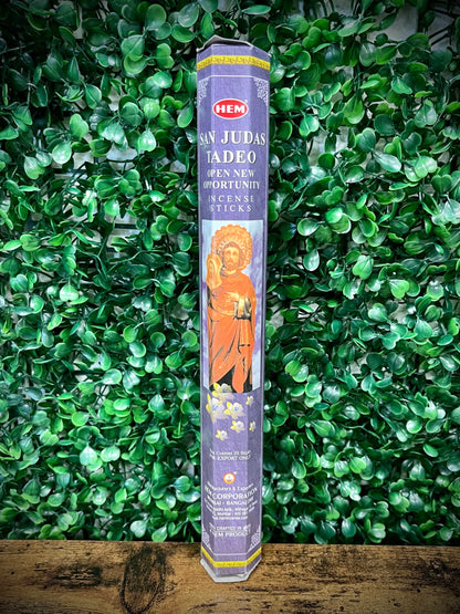 Hem incense stick packaging with a religious figure on a green leafy background