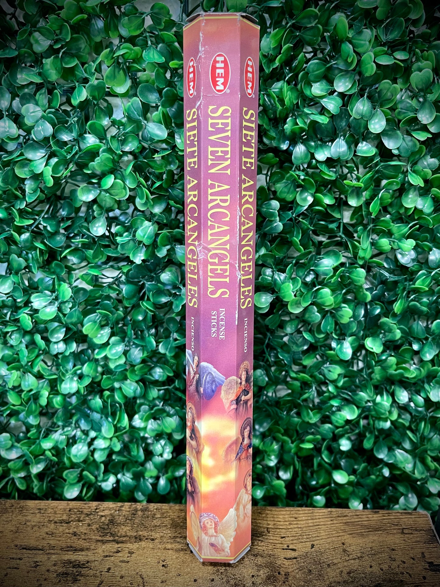 Hexagonal incense stick packaging with 'Seven Archangels' text against a green leafy background